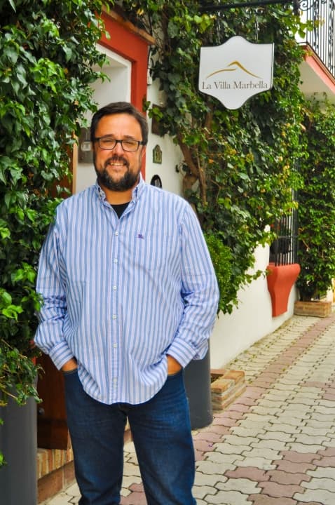 Marcos Torres, Manager at La Villa Marbella, standing at the entrance